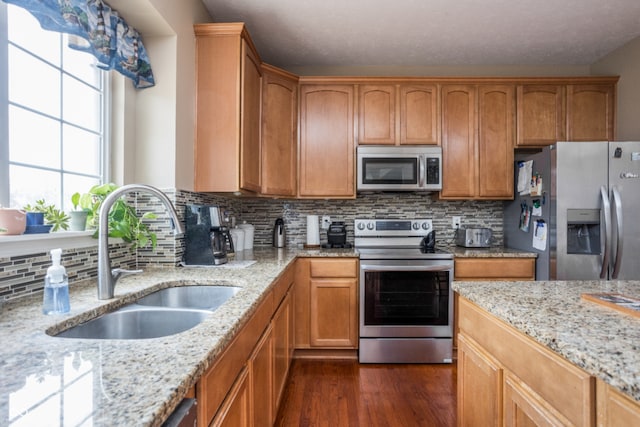 1521 Midnight Pass, Brownsburg, IN 46112 - kitchen featuring stainless steel appliances, dark wood-type flooring, tasteful backsplash, light stone countertops, and brown cabinetry