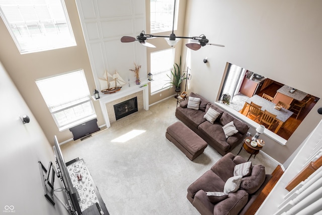 1521 Midnight Pass, Brownsburg, IN 46112 - carpeted living room featuring a towering ceiling, a glass covered fireplace, plenty of natural light, and ceiling fan