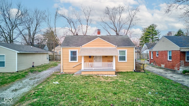 1940 N Drexel Ave, Indianapolis, IN 46218 - rear view of house featuring driveway, covered porch, and a chimney