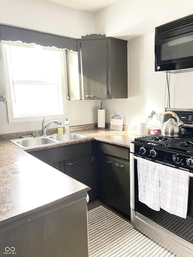 1940 N Drexel Ave, Indianapolis, IN 46218 - kitchen with gas range, black microwave, and gray cabinetry