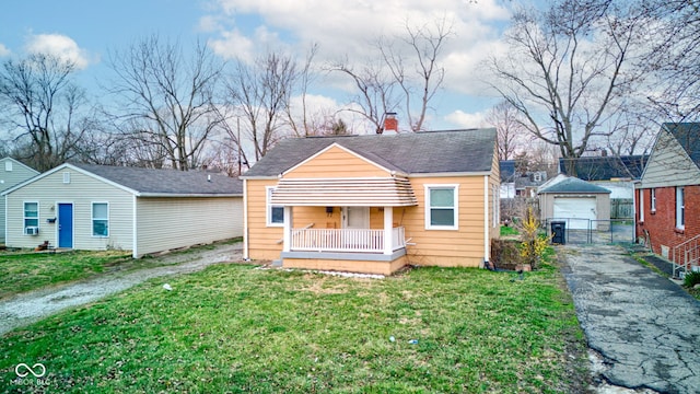 1940 N Drexel Ave, Indianapolis, IN 46218 - view of front of home featuring an outdoor structure, asphalt driveway, and a chimney