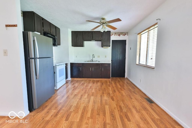 923 Bogalusa Ct, Indianapolis, IN 46217 - kitchen featuring freestanding refrigerator, white range with electric stovetop, light countertops, a ceiling fan, and light wood-style flooring