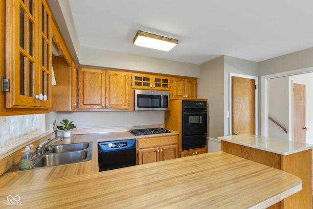 3388 S Leonard Rd, New Palestine, IN 46163 - kitchen featuring black appliances, a warming drawer, light countertops, a peninsula, and glass insert cabinets