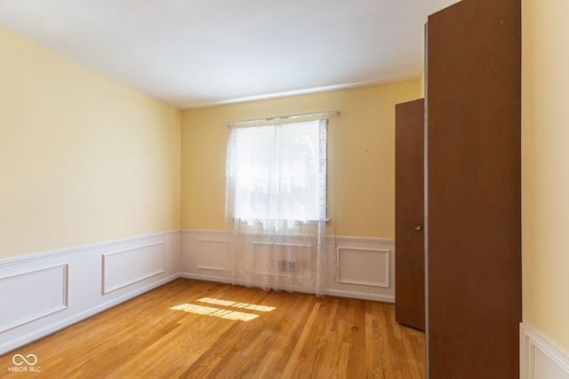 3388 S Leonard Rd, New Palestine, IN 46163 - unfurnished room with light wood-style flooring, wainscoting, and a decorative wall