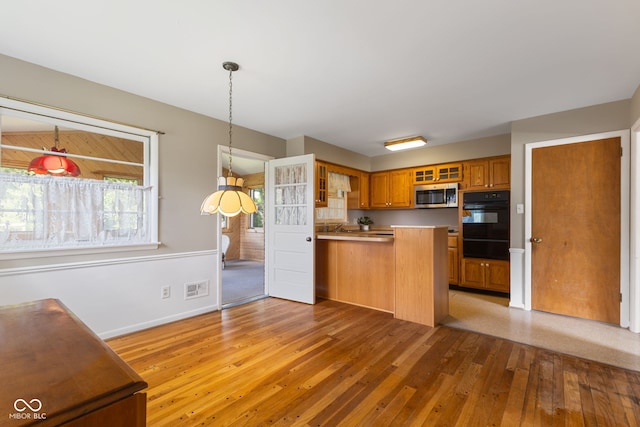 3388 S Leonard Rd, New Palestine, IN 46163 - kitchen featuring stainless steel microwave, oven, a peninsula, light wood-type flooring, and glass insert cabinets