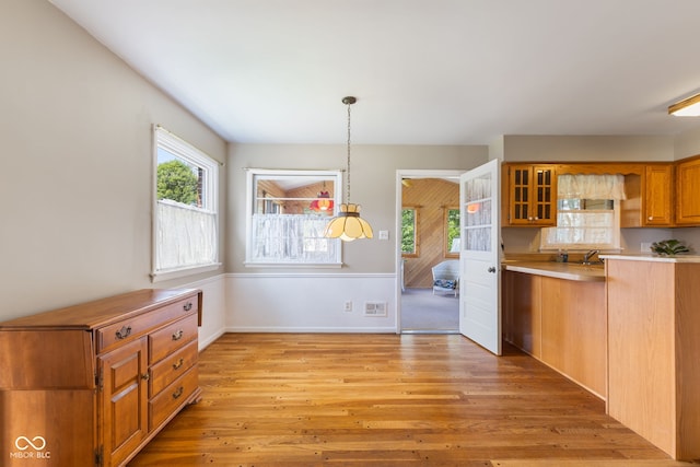3388 S Leonard Rd, New Palestine, IN 46163 - kitchen featuring light wood-style floors, light countertops, open shelves, brown cabinets, and decorative light fixtures