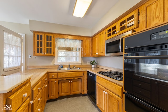 3388 S Leonard Rd, New Palestine, IN 46163 - kitchen featuring black appliances, light countertops, a peninsula, brown cabinetry, and glass insert cabinets