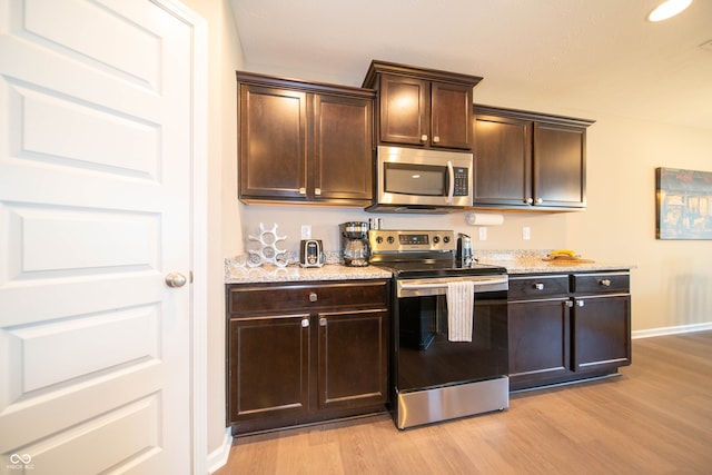 610 Sawtooth St, Westfield, IN 46074 - kitchen with stainless steel appliances, light wood-style flooring, dark brown cabinets, and light stone counters