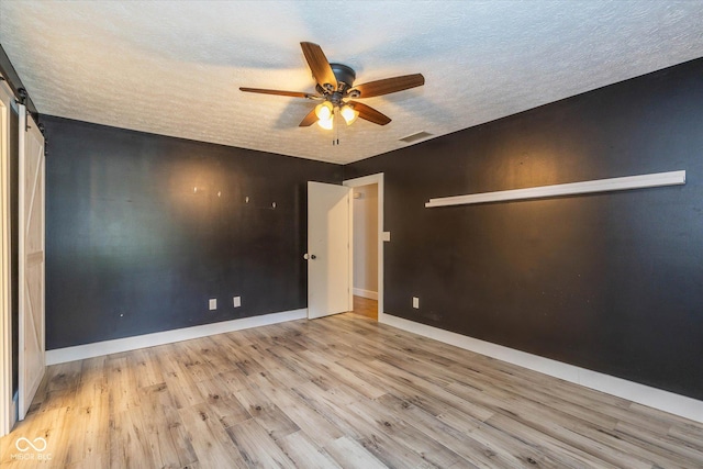 12661 Doe Ln, Indianapolis, IN 46236 - empty room with a textured ceiling, ceiling fan, wood finished floors, and a barn door