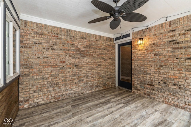 12661 Doe Ln, Indianapolis, IN 46236 - empty room with brick wall, ceiling fan, and wood finished floors