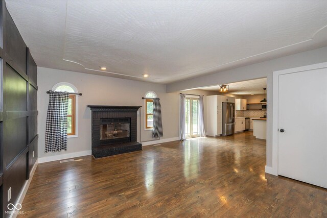 12661 Doe Ln, Indianapolis, IN 46236 - unfurnished living room with a brick fireplace, recessed lighting, and dark wood-style flooring