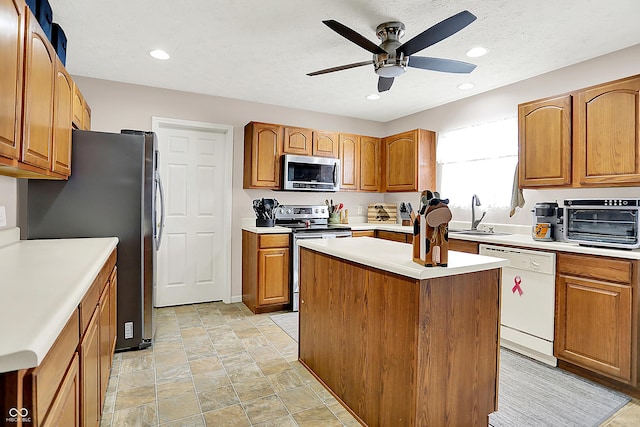 5063 Haywood Ln, Plainfield, IN 46168 - kitchen with appliances with stainless steel finishes, ceiling fan, light countertops, brown cabinets, and recessed lighting