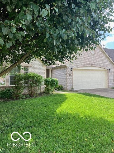 8326 Alcona Dr, Indianapolis, IN 46237 - view of front facade featuring brick siding, an attached garage, a front yard, and concrete driveway