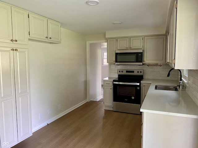1400 Evelyn Ln, Anderson, IN 46017 - kitchen with appliances with stainless steel finishes, light countertops, wood finished floors, and decorative backsplash