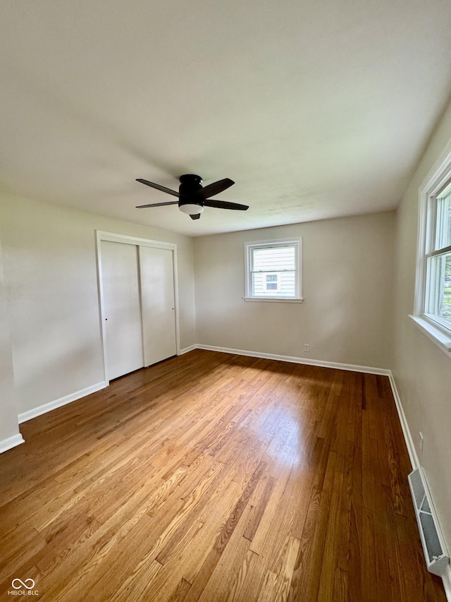 1400 Evelyn Ln, Anderson, IN 46017 - unfurnished bedroom with multiple windows, wood finished floors, and a closet