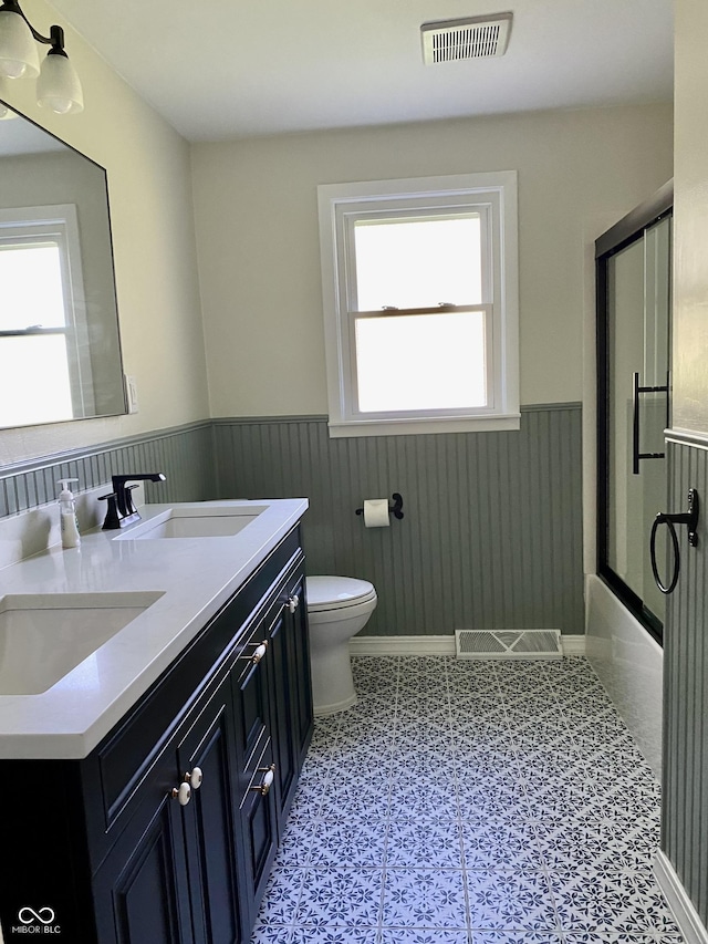 1400 Evelyn Ln, Anderson, IN 46017 - full bath featuring wainscoting, double vanity, and enclosed tub / shower combo