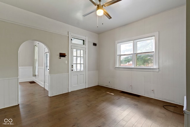 29 E Caven St, Indianapolis, IN 46225 - spare room with a ceiling fan, plenty of natural light, arched walkways, wood finished floors, and a wainscoted wall