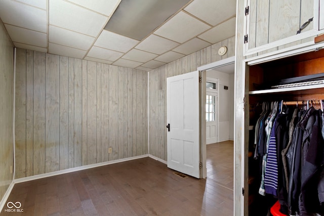 29 E Caven St, Indianapolis, IN 46225 - unfurnished bedroom with wood walls, hardwood / wood-style floors, a drop ceiling, and a closet