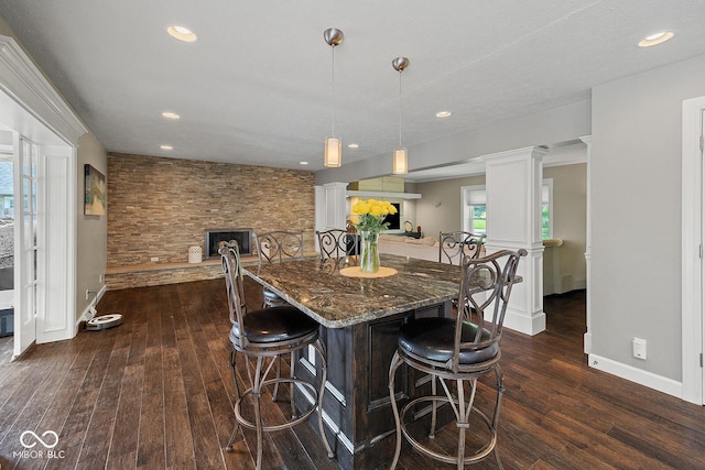 3710 Canada Ct, West Lafayette, IN 47906 - kitchen featuring decorative columns, dark wood-style floors, dark stone countertops, a breakfast bar area, and recessed lighting