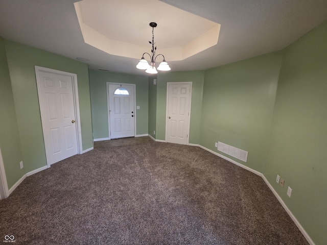 21 Watson Dr, Trafalgar, IN 46181 - carpeted empty room with a raised ceiling and a chandelier