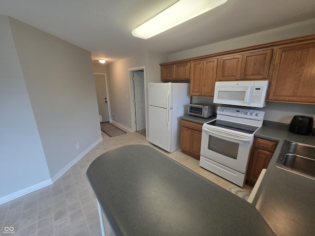 21 Watson Dr, Trafalgar, IN 46181 - kitchen featuring white appliances, brown cabinets, dark countertops, and light flooring