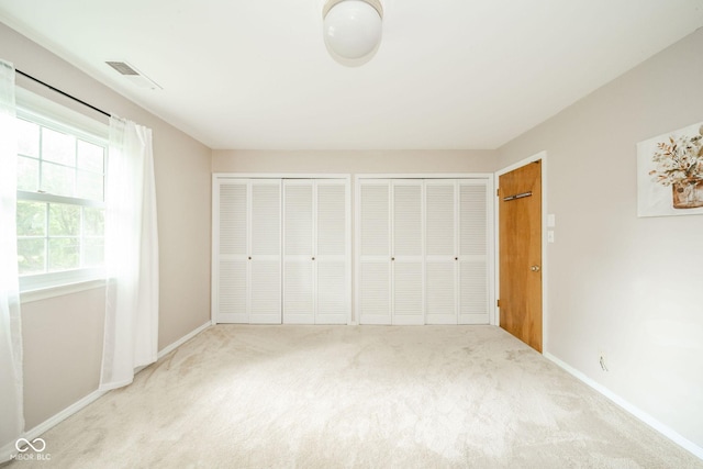 2613 W Queensbury Rd, Muncie, IN 47304 - unfurnished bedroom featuring multiple closets and carpet flooring