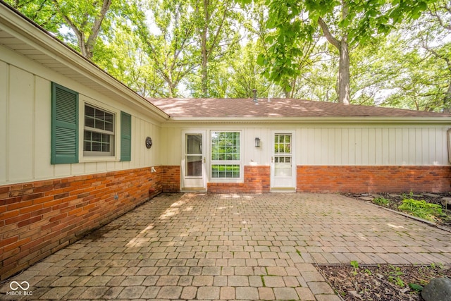 2613 W Queensbury Rd, Muncie, IN 47304 - property entrance with brick siding, a patio, and board and batten siding