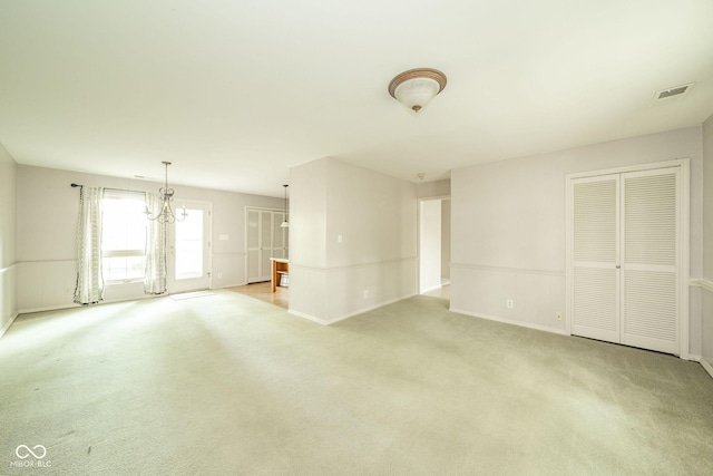 2613 W Queensbury Rd, Muncie, IN 47304 - unfurnished living room featuring light colored carpet and a chandelier