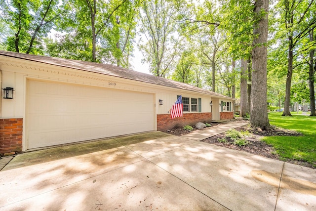 2613 W Queensbury Rd, Muncie, IN 47304 - ranch-style house featuring brick siding, concrete driveway, and a garage