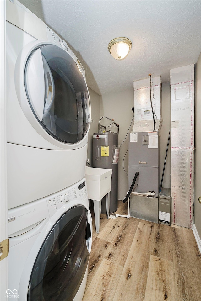 16629 Greensboro Dr, Westfield, IN 46074 - laundry room featuring stacked washing machine and dryer, wood finished floors, heating unit, and electric water heater