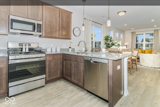 3933 Wren Dr, Brownsburg, IN 46112 - kitchen with appliances with stainless steel finishes, light wood-type flooring, a peninsula, plenty of natural light, and recessed lighting