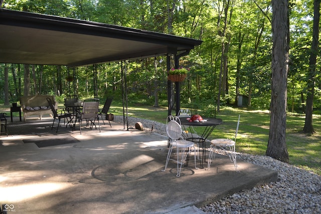 704 S Rockfield Rd, Veedersburg, IN 47987 - view of patio with outdoor dining space and a wooded view