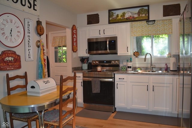 704 S Rockfield Rd, Veedersburg, IN 47987 - kitchen featuring appliances with stainless steel finishes, dark countertops, white cabinets, and light wood-style floors