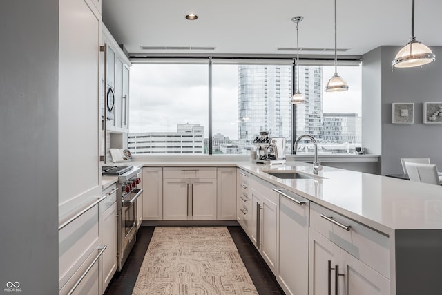 225 N New Jersey St Unit 52, Indianapolis, IN 46204 - kitchen featuring stainless steel stove, light countertops, dark wood-style flooring, a city view, and recessed lighting