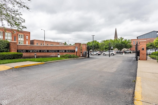 225 N New Jersey St Unit 52, Indianapolis, IN 46204 - view of asphalt road with curbs, street lights, a gate, sidewalks, and a gated entry