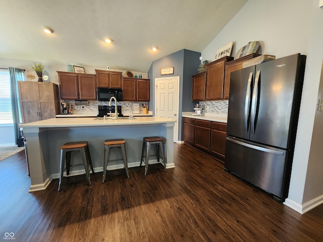 7511 Eddie Ln, Camby, IN 46113 - kitchen with freestanding refrigerator, black microwave, dark wood finished floors, backsplash, and light countertops
