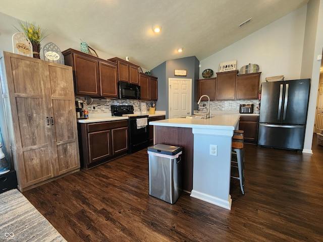 7511 Eddie Ln, Camby, IN 46113 - kitchen with black appliances, lofted ceiling, light countertops, tasteful backsplash, and dark wood finished floors