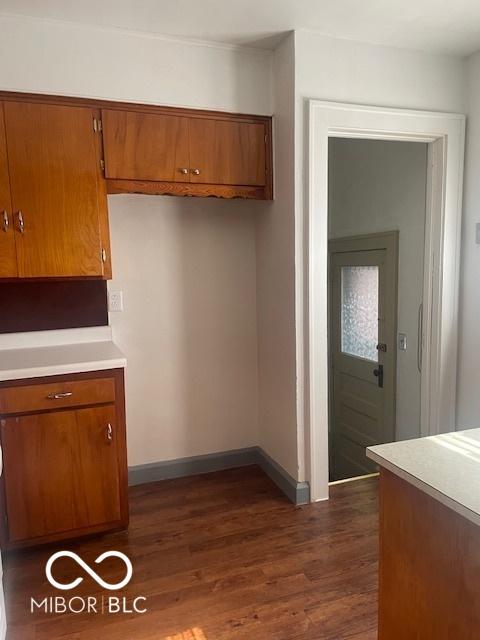 416 W 21st St, Anderson, IN 46016 - kitchen with brown cabinets, dark wood-type flooring, and light countertops
