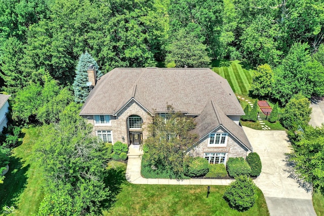 13779 Stone Dr, Carmel, IN 46032 - view of front of home featuring stone siding, a chimney, and concrete driveway