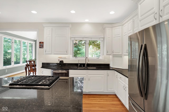 13779 Stone Dr, Carmel, IN 46032 - kitchen featuring appliances with stainless steel finishes, plenty of natural light, light wood-style flooring, white cabinets, and recessed lighting