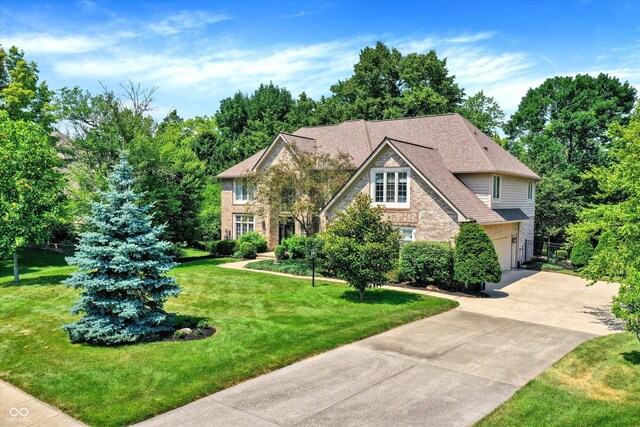 13779 Stone Dr, Carmel, IN 46032 - view of front of house with stone siding, driveway, a garage, and a front lawn