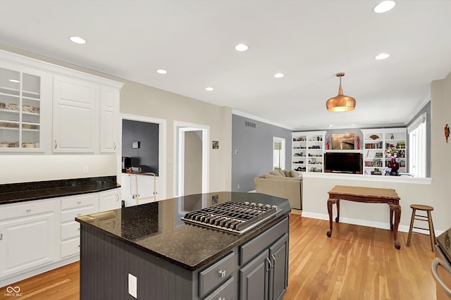 13779 Stone Dr, Carmel, IN 46032 - kitchen with stainless steel gas cooktop, gray cabinets, light wood finished floors, white cabinets, and glass insert cabinets
