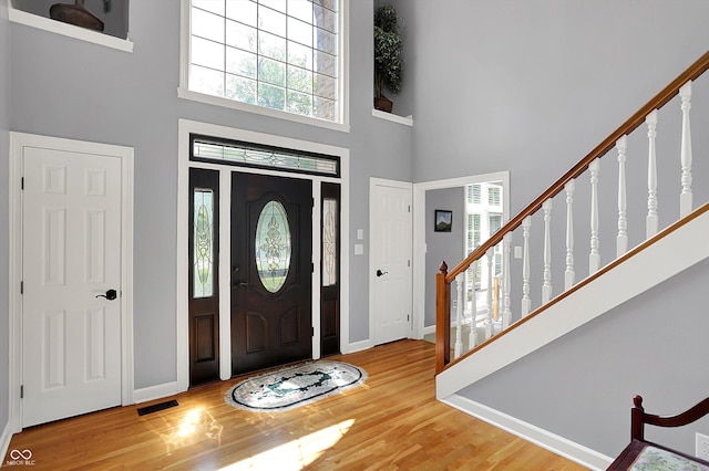 13779 Stone Dr, Carmel, IN 46032 - foyer featuring wood finished floors, a high ceiling, and stairs