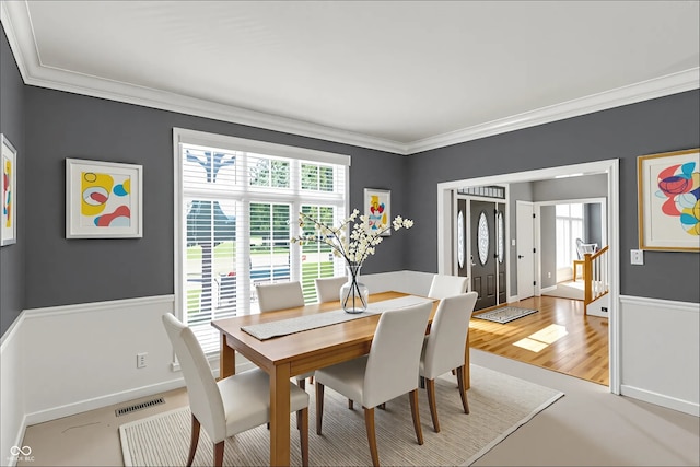 13779 Stone Dr, Carmel, IN 46032 - dining space with healthy amount of natural light, ornamental molding, light wood-style flooring, and stairs