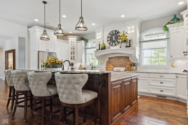 3399 Nottinghill Blvd, Plainfield, IN 46168 - kitchen with stainless steel fridge, decorative backsplash, a center island with sink, dark wood finished floors, and recessed lighting