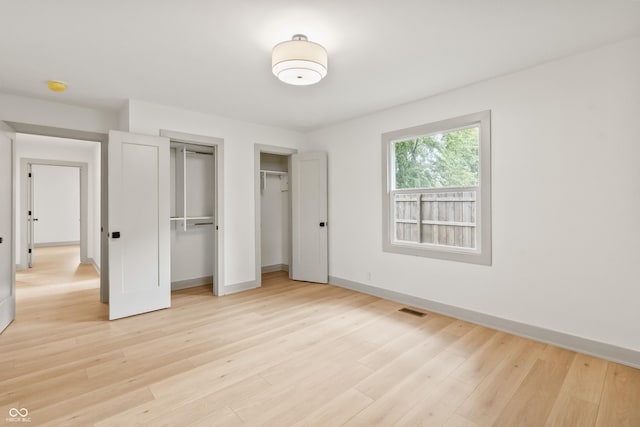 8246 Windcombe Blvd, Indianapolis, IN 46240 - unfurnished bedroom featuring multiple closets and light wood-style flooring