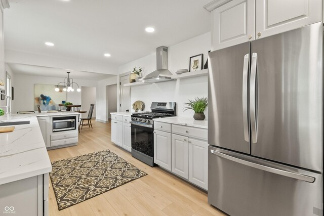 8246 Windcombe Blvd, Indianapolis, IN 46240 - kitchen featuring stainless steel appliances, wall chimney exhaust hood, a peninsula, light wood-style flooring, and open shelves