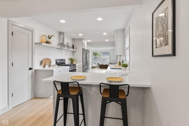8246 Windcombe Blvd, Indianapolis, IN 46240 - kitchen featuring wall chimney range hood, stainless steel appliances, open shelves, a kitchen bar, and light wood-type flooring