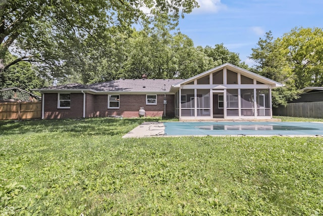 8246 Windcombe Blvd, Indianapolis, IN 46240 - rear view of house with a sunroom, a fenced backyard, a patio area, and brick siding