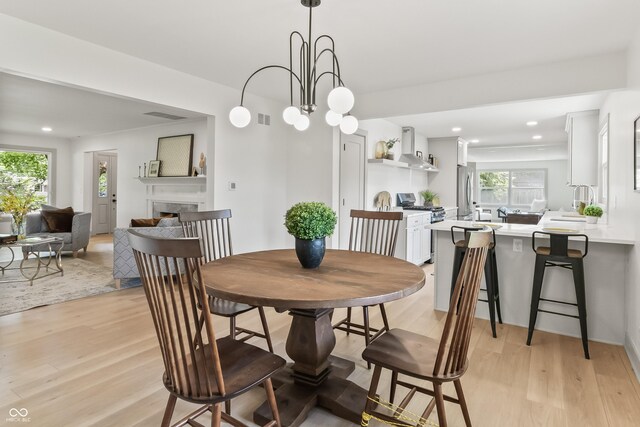 8246 Windcombe Blvd, Indianapolis, IN 46240 - dining space featuring light wood finished floors, a high end fireplace, and recessed lighting